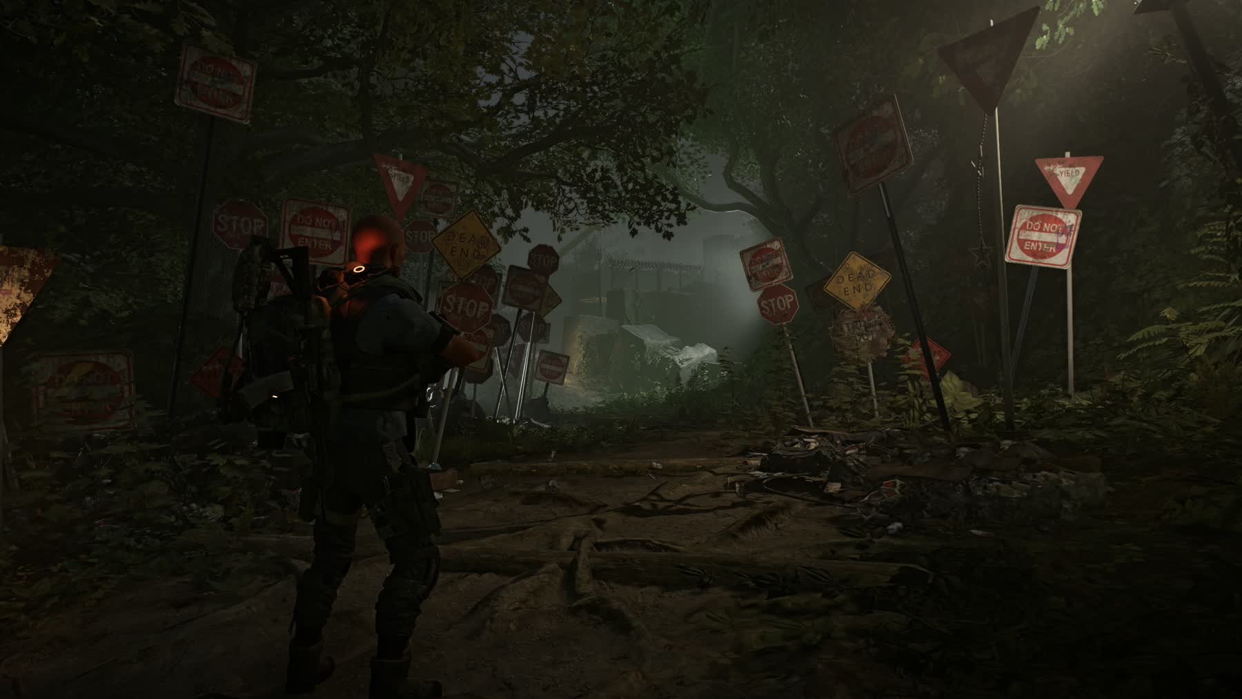 An agent approaches a wooded path crowded with warning signs in The Division 2 Echoes of Central Park